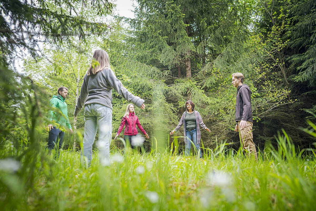 Waldlichtung, Teilnehmer stehen im Kreis auf einer Wiese