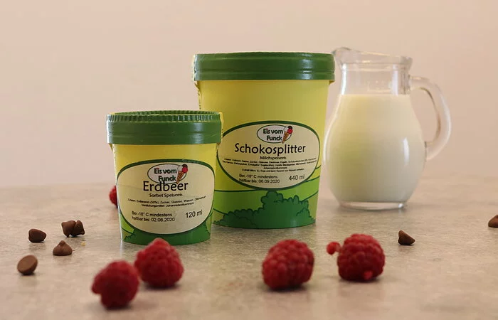 Zwei Eisbecher mit Bauernhofeis mit Himbeerdeko