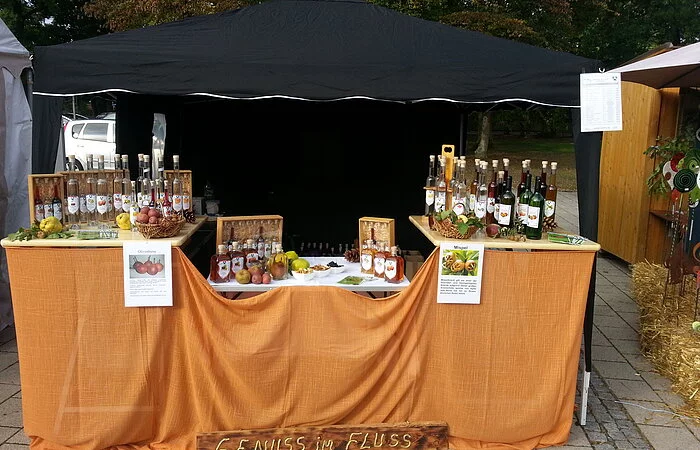 Genuss im Fluss / Markt Verkaufsstand mit verschiedenen Obstbrandflaschen