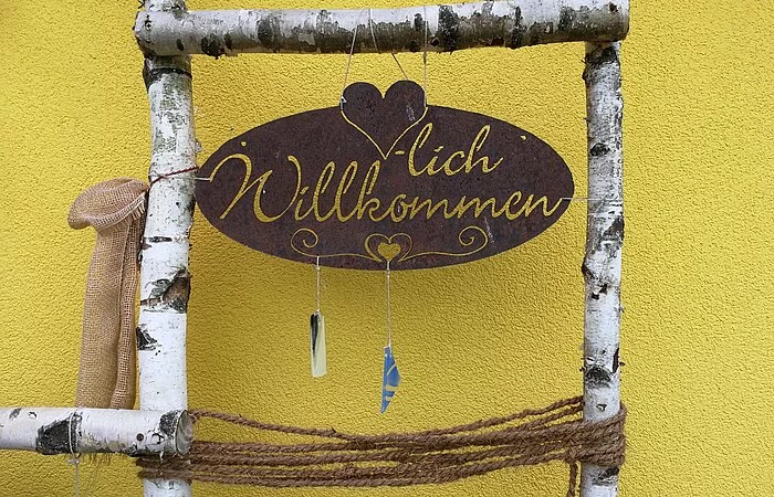 Willkommensschild mit Birkenastumrandung