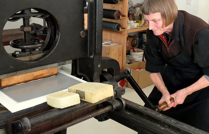 Lithografie Werkstatt
Li Portnlänger an der Druckmaschine
