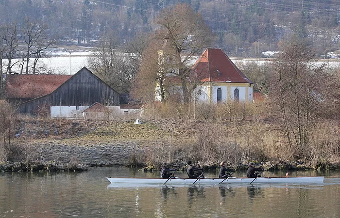 Ein Ruderboot auf dem Kanal vor der Wallfahrtskirche Griesstetten