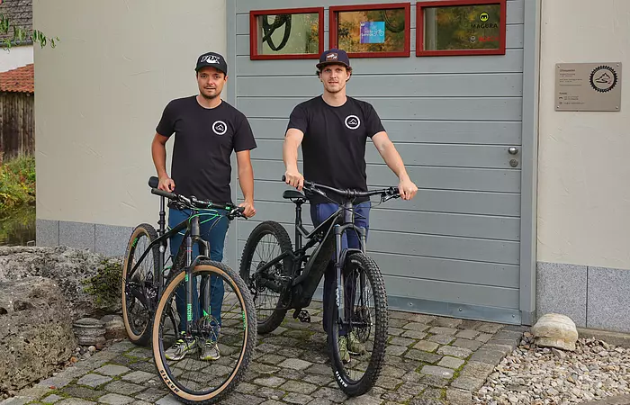 Auf dem Bild sieht man die beiden Inhaber (Schmid Maximilian u. Quirin) vor der S2 Radlwerkstatt.