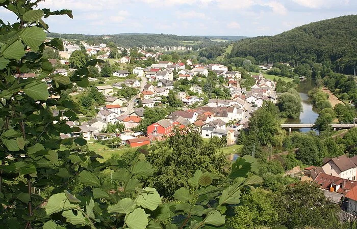 Solnhofen von oben. Eingerahmt von grünen Blättern und dem bewaldeten Hängen.