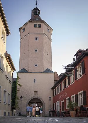 Bei einer Gästeführung schreiten Touristen durch den Torbogen des Blasturms