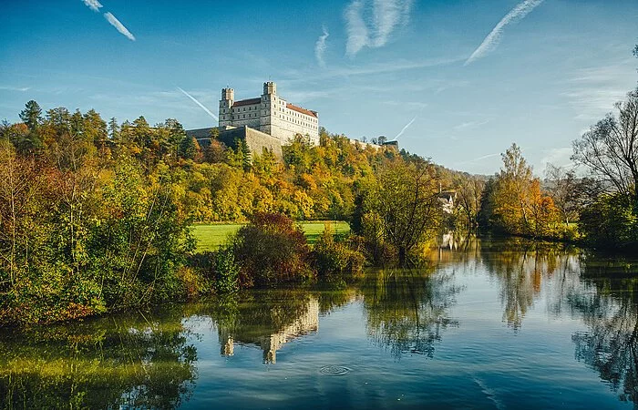 In der linken oberen Ecke thront die Willibaldsburg, ein hellgrauer, rechteckiger Bau mit vielen Fenstern und zwei Türmen an den vorderen Ecken.  Direkt davor zeigt sich ein Teil der schützenden Bastionsmauer.  Die Burg selbst steht auf einem bewaldeten Berg. Die untere Hälfte des Bildes wird von dem Fluss „Altmühl” eingenommen, die sich im Tal um die Willbaldsburg schlängelt.