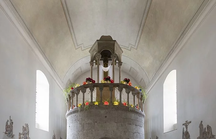 Bei der Aufnahme handelt es sich um den Innenraum der ehemaligen Kapuzinerkirche. Das Grabmal, das als Nachbildung des Heiligen Grabs bekannt ist, bildet das Zentrum der Aufnahme. Es liegt in einem Bau, der turmförmig ist. Auf ihm steht ein großes goldenes Kreuz. An den Wänden rund um den Turm ist er Kreuzweg Jesu abgebildet. Im Vordergrund steht ein kleinerer Altar.