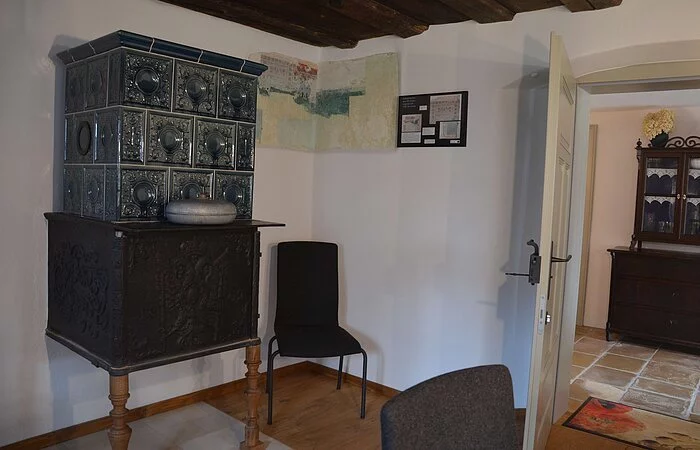 Im Hintergrund einen Kachelofen in der sogenannten Stubn des Gasthofs.