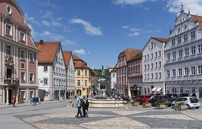 Zentrum des Bildes ist ein Brunnen aus Stein, auf dem die Statue des Hl. Willibalds thront. Neben dem Brunnen verlaufen zwei Häuserzeilen, die hinter dem Brunnen zusammenlaufen. Verschiedene Geschäfte und Cafés säumen die Straßen. Die Fassaden der Häuser sind in verschiedenen Farben gehalten. Der ganze Platz ist in dreiecksform angeordnet und mit Kopfsteinpflaster versehen.