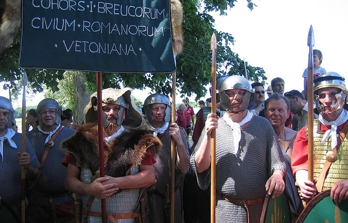 Eine große Gruppe Männer ist verkleidet als römische Legionäre. Die Männer tragen Helme, Lanzen, Kettenhemden oder Brustpanzer.