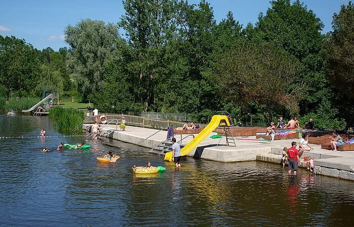 Badende im Wörnitz-Flussfreibad in Oettingen. Auf dem Bild ist auch die Rutsche für die Kinder zu sehen.