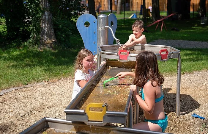 Drei Kinder am Wasserspiel im Wörnitzfreibad
