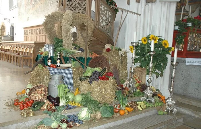 Die Erntedankdekoration mit zur Krone gebundenem Getreide und verschiedenem Obst und Gemüse.