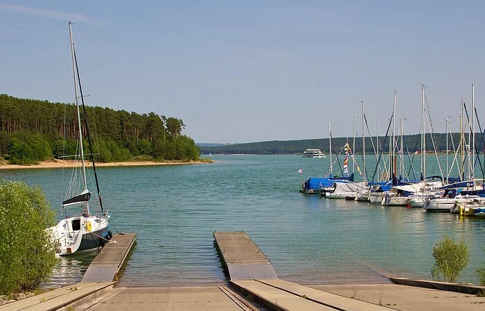 Slipanlage am Brombachsee. Eine schräge Ebene, bei welcher die Segelbotte ins wasser gelassen werden. Rechts ein kleiner Segelhafen.