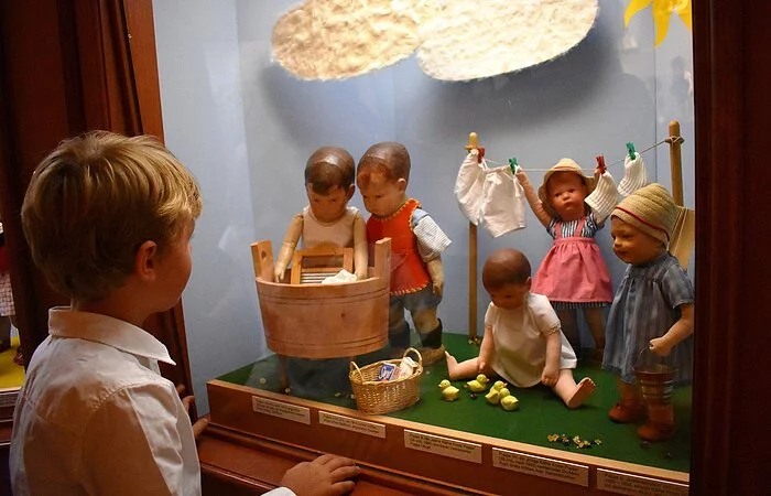 Ein Junge betrachtet eine Puppenszene im Käthe Kruse Puppenmuseum.