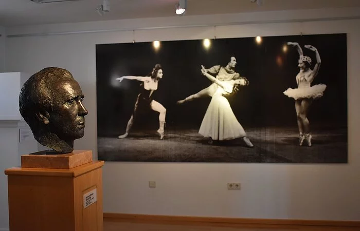 Eine Büste von Werner Egk und Ballett-Bilder an der Wand