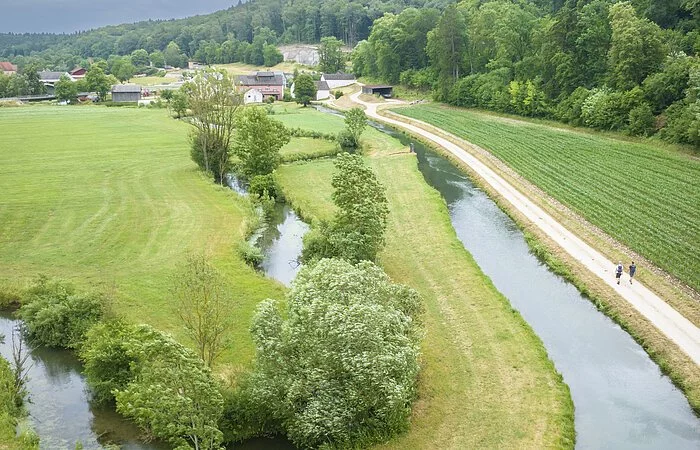 Drohnenaufnahme des Möhrenbachtals. Blick über die weite Landschaft, durch die der Möhrenbach in natürlichem Flussbett mäandriert.
