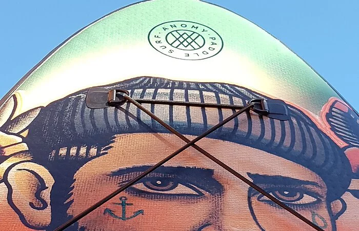 Der obere Teil eines Wakeboards. Darauf ein gemalter Mann mit braunem Bart und grauer Mütze.