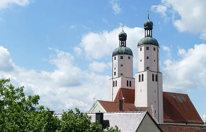 Blick auf die Türme der Stadtpfarrkirche mit weiß blauem Himmel