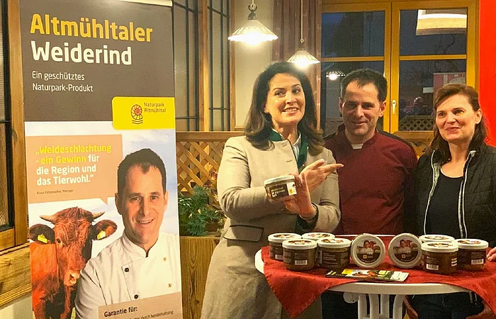 Neben dem Altmühltaler Weiderind steht die Landwirtschaftsministerin Kaniber und daneben das Ehepaar Eichenseher. Vor Ihnen ein Bistrotisch mit Weiderindprodukten.