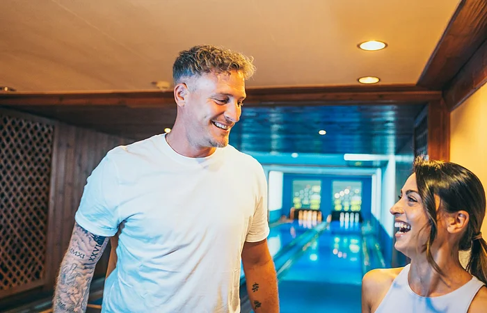 Ein Pärchen steht vor der Kegelbahn und freut sich auf ihr nächstes Spiel.