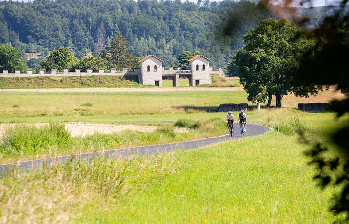 Zwei Rennradfahrer fahren den leichten Anstieg hinter dem Kastell Vetoniana bei Pfünz hoch