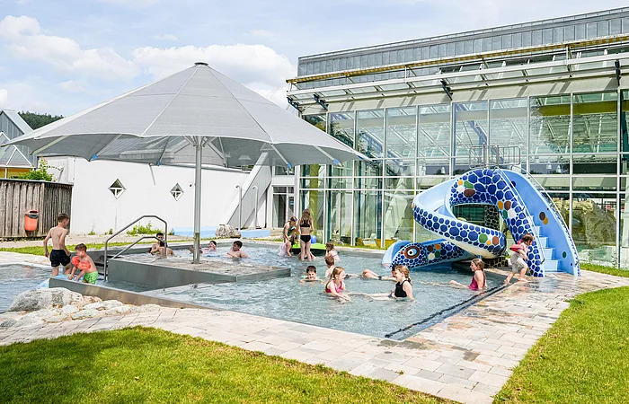 Außenbereich des Sport- und Freizeitbades Greding mit Planschbecken und Wasserrutsche