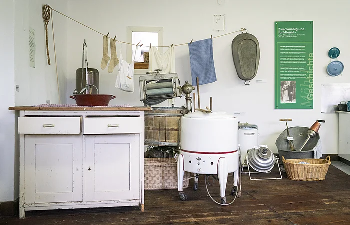 Blick in die Abteilung Leben im 20. Jahrhundert der Dauerausstellung; Zu sehen sind Exponate aus dem Bereicht „Wäsche waschen wie Früher“
