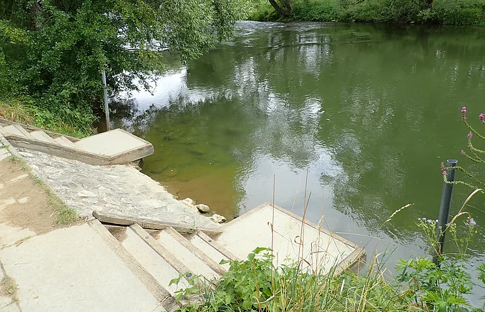 Anlegestelle mit Betonstufen und Holzrutsche für Bootswanderer.