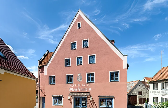 Gästehaus in rosa mit blauen Akzenten.