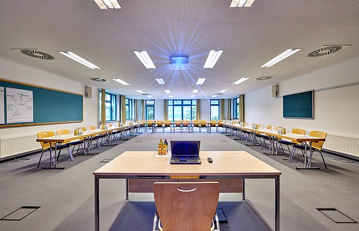 Die Tische sind in U-Form-Bestuhlung mit Blick nach vorne zu einem weiteren Tisch gerichtet
.