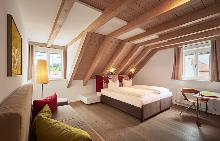 Ein Schlafzimmer mit Doppelbett in Naturfarbtönen eingerichtet.