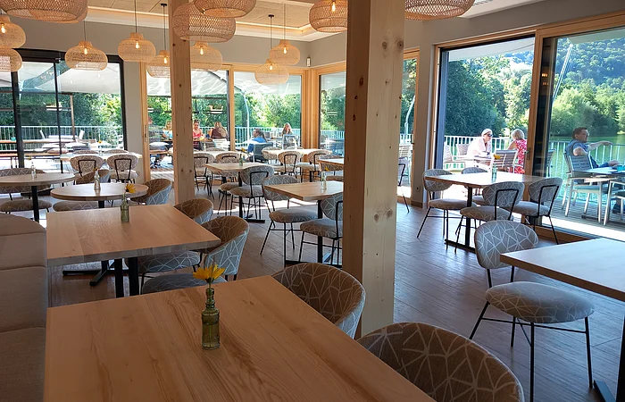 Das Restaurant ist mit Holzmöbel und Lampionlampen eingerichtet. Es ist hell und freundlich mit Blick auf den Kratmühlsee.