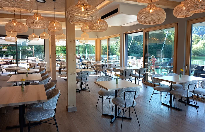 Der helle und modern eingerichtete Essbereich direkt am See punktet mit Ambiente und Aussicht.