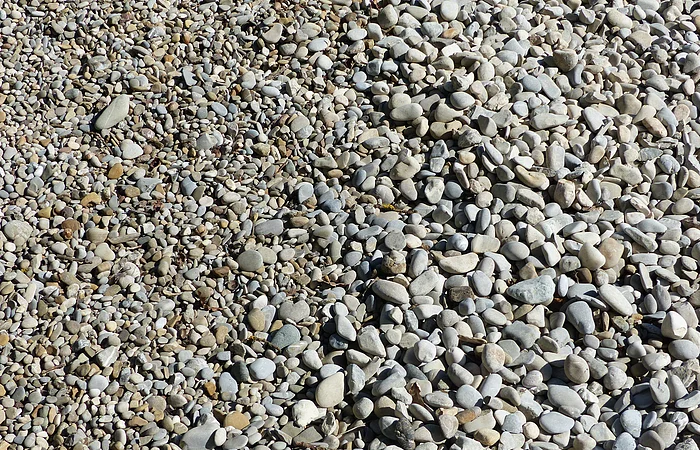 Eine Fläche mit vielen kleinen und mittelgroßen Kieselsteinen in verschiedenen Grautönen.