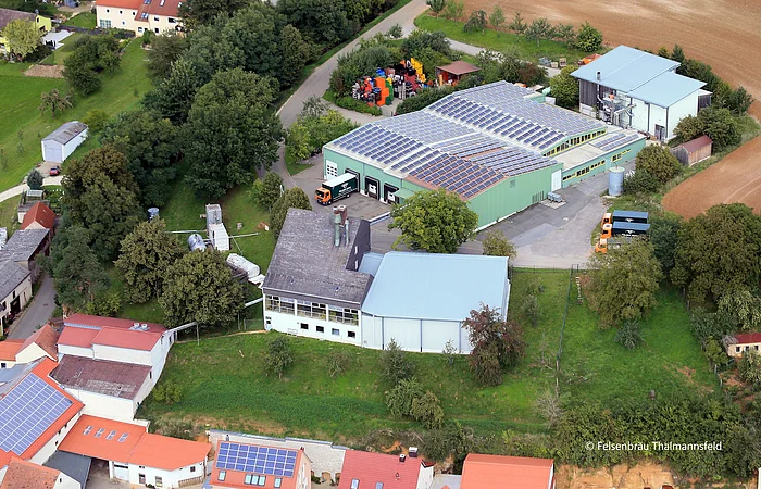 Luftbild eines Brauereigeländes. Große Lagerhalle mit Solarpanele auf dem Dach.