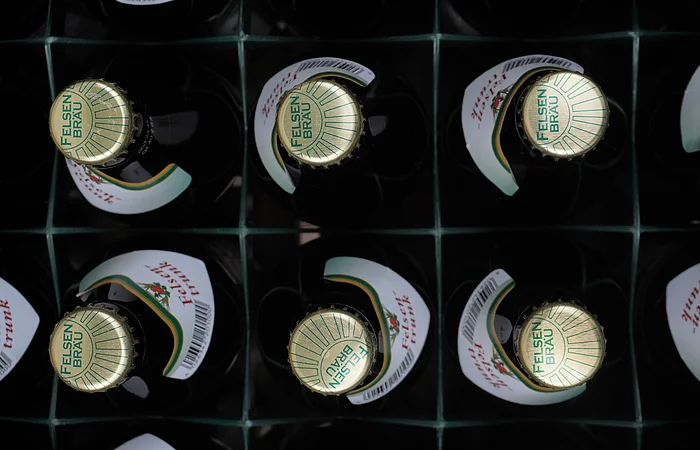 Kiste mit zwölf Felsenbräu-Bierflaschen, Draufsicht auf die Kronkorken.