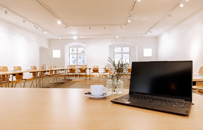 Die holzigen Tische sind in einer Carré-Bestuhlung aufgestellt.