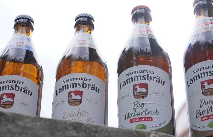 Vier Flaschen Neumarkter Lammsbräu Bier, verschiedene Sorten, von unten fotografiert.
