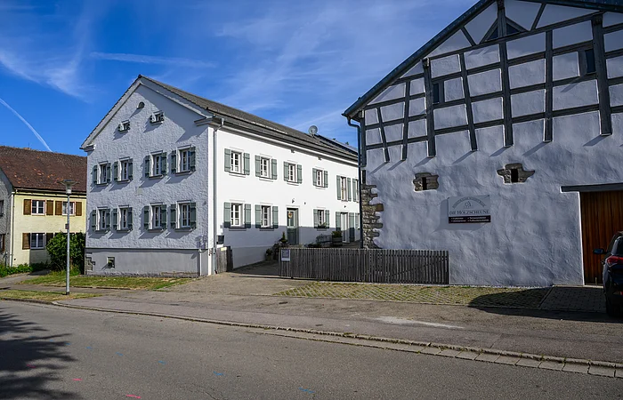 Jurahäuser in Dettenheim, an der Hauptstraße gelegen, die Häuser sind in weiß gehalten und die Scheune verfügt über ein Holzfachwerk