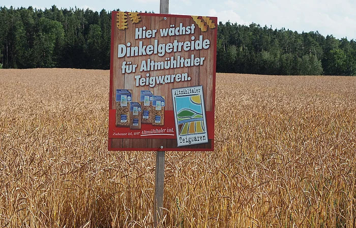 Schild in einem Dinkelfeld mit der Aufschrift "Hier wächst Dinkelgetreide für Altmühltaler Teigwaren".