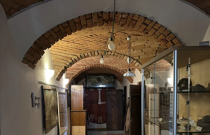 In einem gemauerten Gewölbe stehen Vitrinen mit Exponaten an den Wänden