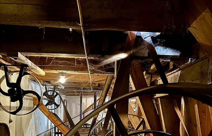 In dem dunklen Innenraum sind des Mühlenmuseums sind die Mühlräder zu sehen