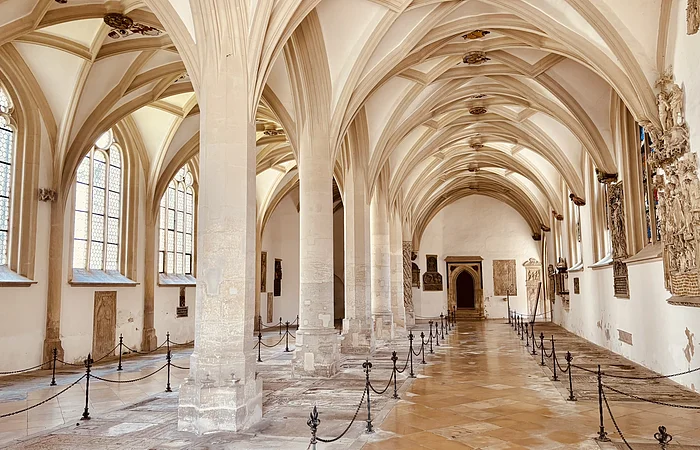 Ein von Säulen gestütztes Gewölbe. Ein abgesperrter Weg führt nach hinten durch das Gewölbe