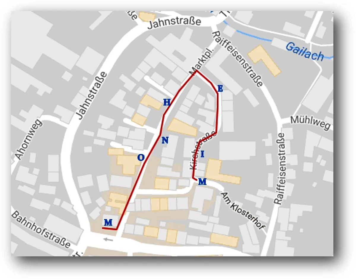 Kartenausschnitt aus Monheim mit Straßen und markiertem Weg von der Bahnhofstraße über Jahnstraße, dem Marktplatz, der Kirchstraße bis zur Raiffeisenstraße.