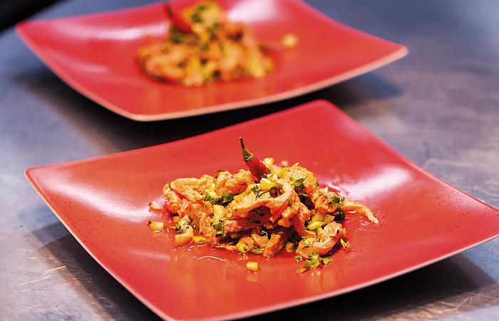 Forellen-Rote-Bete-Piccata auf roten Tellern.