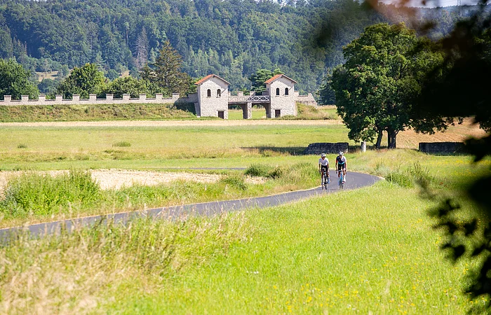 Zwei Rennradfahrer fahren den leichten Anstieg hinter dem Kastell Vetoniana bei Pfünz hoch