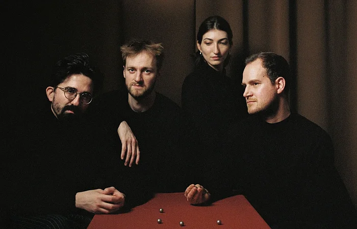 Sie sehen das Quatuor Agate in der aktuellen Besetzung an einem Tisch sitzen