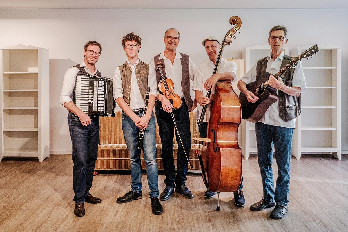 Auf diesem Bild sieht man fünf Musiker mit Ihren Instrumenten.