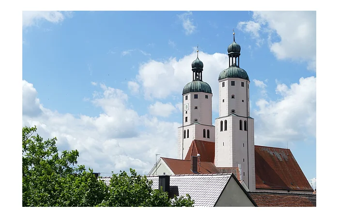 Blick auf die Türme der Stadtpfarrkirche mit weiß blauem Himmel